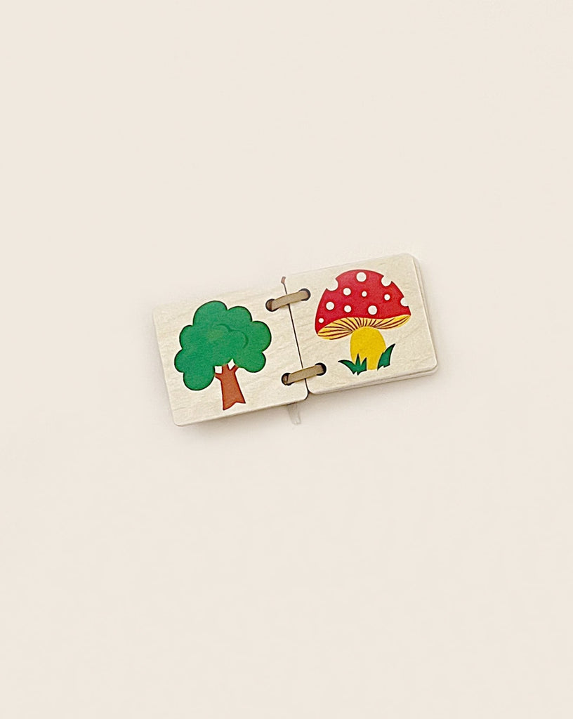 Two Mini Wooden Picture Books - Nature connected, featuring illustrated segments of a tree and a colorful mushroom on a plain background, crafted from sustainably harvested trees.