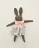 A handmade Polka Dot Club Large Brown Rabbit in Hand Knit Dress with a peach bow and white dress against a light background. The rabbit, hand embroidered in Peru, has long ears, blue stitched eyes, and an X for a mouth.