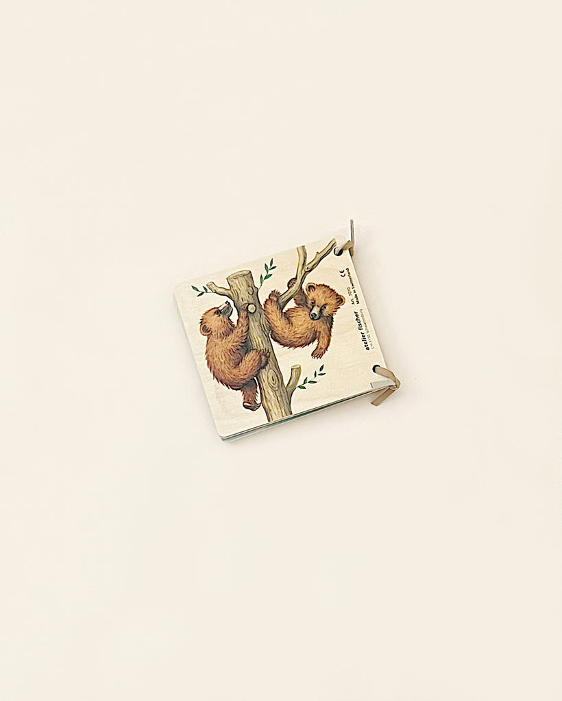 A small, vintage wooden picture book with an illustrated cover featuring two bears on a tree branch, positioned on a plain, light beige background.