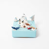 A whimsical miniature scene on a light blue square platform featuring arctic animals like penguins and a polar bear, with icebergs, seals, a whale tail, and various small accessories, crafted inside the Wooden Antarctica Music Box.