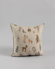 A Coral & Tusk Woodland Friends Pillow with a beige background featuring various animals dressed in human clothing, such as a fox in a suit and a foraging chipmunk with a hat, illustrated in a whimsical style