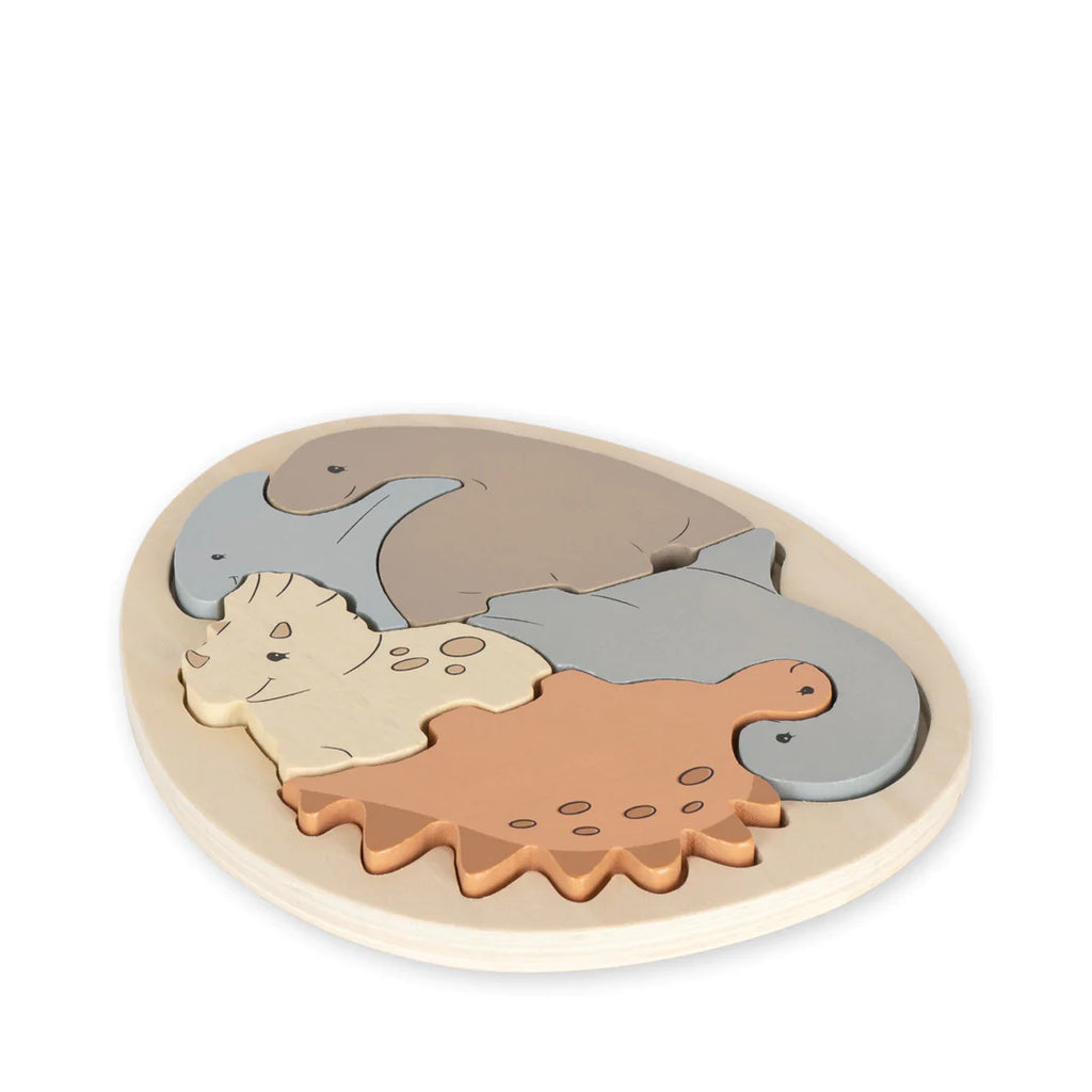 Sentence with product name: A Dinosaur Egg Puzzle on a white background, featuring pieces shaped like dinosaurs in various colors including gray, brown, and beige, nested within an oval-shaped dinosaur egg puzzle board.