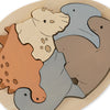 Dinosaur Egg Puzzle featuring interlocking pieces shaped like a bear, a dolphin, and a seal, each colored with non-toxic water-based paint in different shades—brown, gray, and light gray.