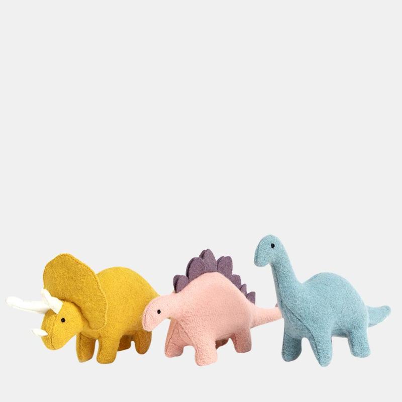 three stuffed dinosaur toys standing.