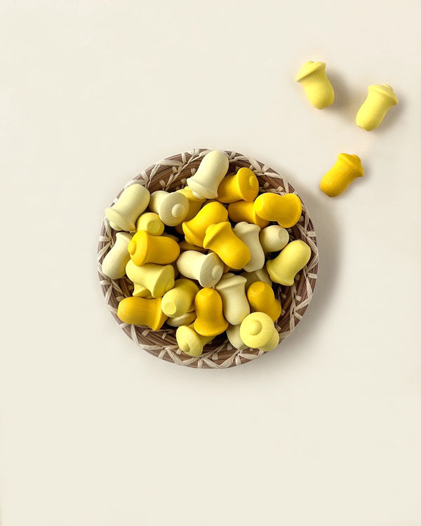 A Grapat Mandala Tulip filled with yellow and white twist candies on a light-colored background, with a few candies scattered alongside, all crafted with non-toxic finishes.