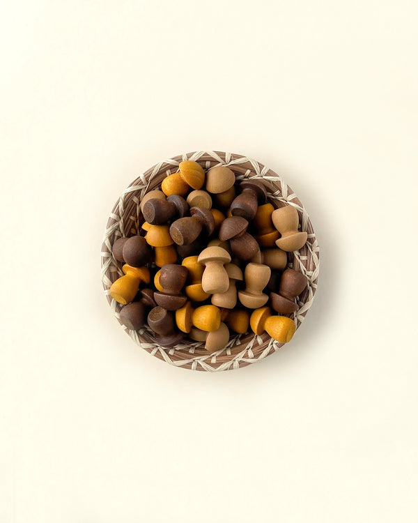 A bowl filled with Grapat Mandala Little Mushrooms from sustainable forests on a light-colored background, with the bowl displaying a geometric pattern.
