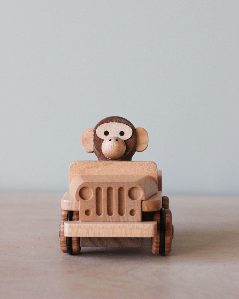 Wooden car toy with a monkey driving it. 