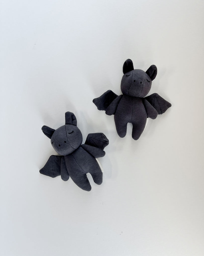 2 dark gray bat rattles. White background. 