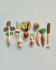 An arrangement of the 10 Piece Handmade Wooden Vegetable Set on a pale background, including carrots, onions, a knife, and a rolling pin.