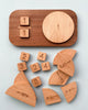 A Wooden Fraction Puzzle - Made in USA on a light background, designed for preschoolers, featuring a central round piece numbered "1" and various shaped blocks around it, each bearing different numbers and mathematical symbols.