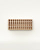 A Crayon Tray For Stockmar - 24 x 24 Slots with multiple rows of circular indentations for educational purposes, placed on a light beige background.
