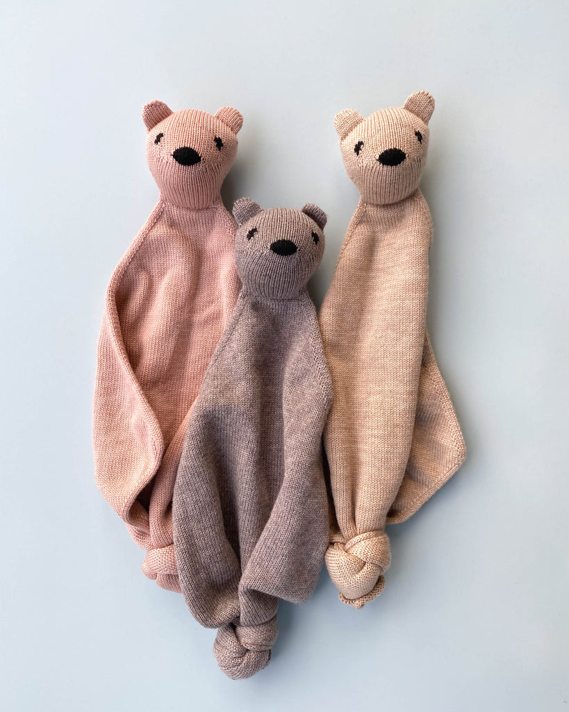 a group shot of three small merino wool lovey each with a head of a teddy bear at the op.
