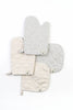 Four striped Play Oven Mitt Sets and potholders in neutral colors, each featuring a small embroidered emblem, arranged overlapping each other on a white background.