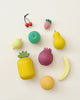 A collection of Raduga Grez Handmade Painted Wooden Fruits toys arranged on a light background, including a cherry, carrot, pear, lemon, and others.