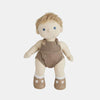 A Olli Ella Dinkum Doll with blue eyes and blond hair, dressed in a brown knitted romper and white socks with brown shoes, isolated on a white background.