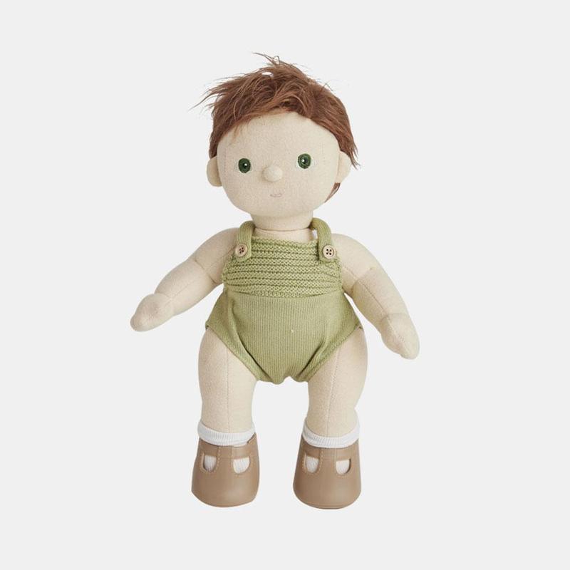 A cuddly Olli Ella Dinkum Doll with short brown hair and green eyes, dressed in a light green jumper with a button, and wearing beige shoes with brown soles.