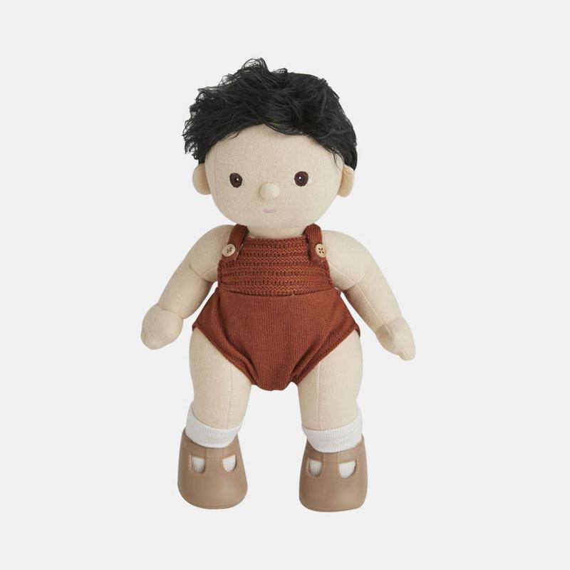 A Olli Ella Dinkum Doll with black hair, featuring a surprised expression, dressed in red overalls and brown shoes, isolated on a white background.