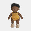 A Olli Ella Dinkum Doll with dark skin and curly black hair, dressed in a mustard yellow knitted jumpsuit with white shoes, isolated on a light background.
