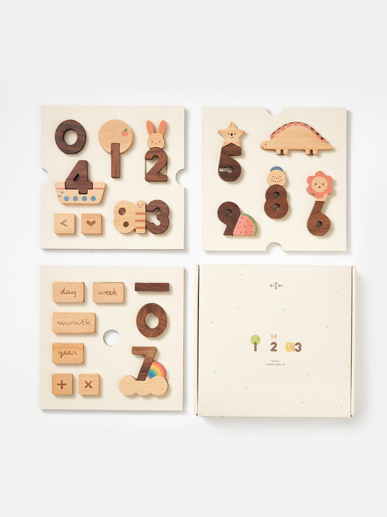A children's educational Numbers Play Block Set featuring pieces shaped like number blocks, animals, and nature symbols, laid out next to its box with slots for organizing the pieces.