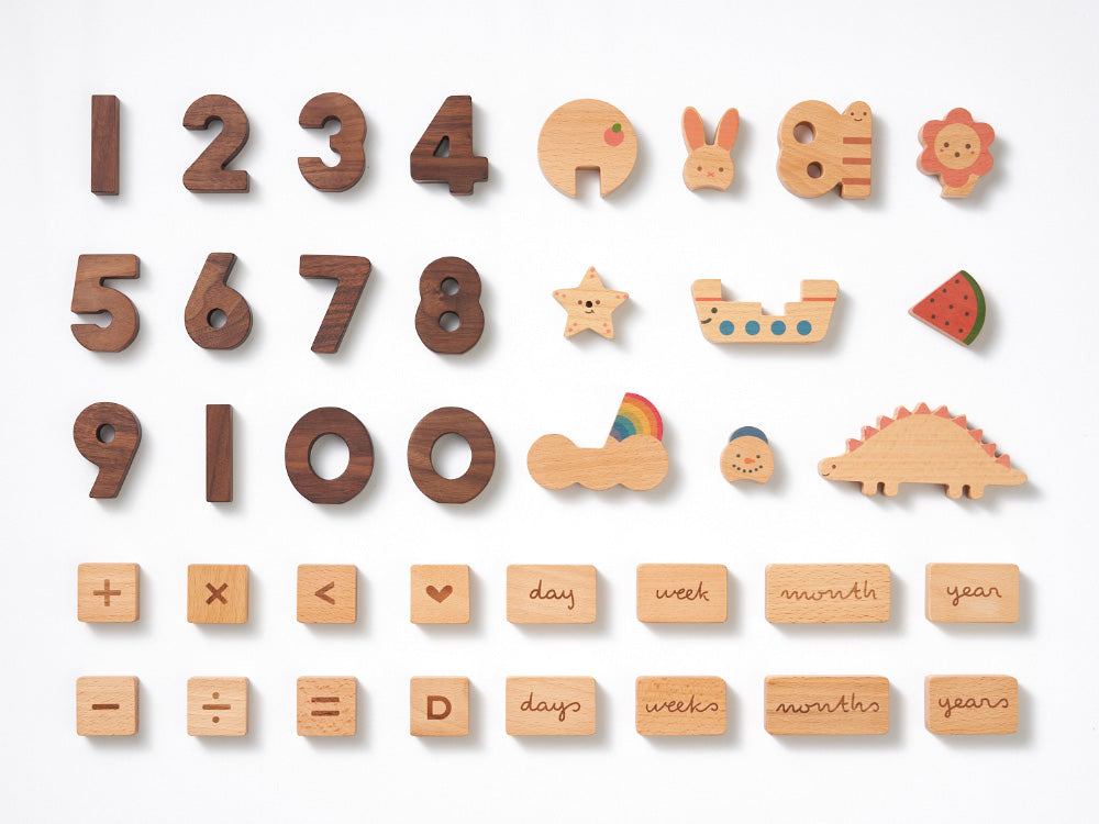A variety of wooden educational toys including Numbers Play Block Set, simple arithmetic symbols, objects like a boat and fruits, and blocks with time units on a white background.