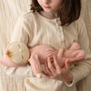 Child holding a sleeping pink doll. 