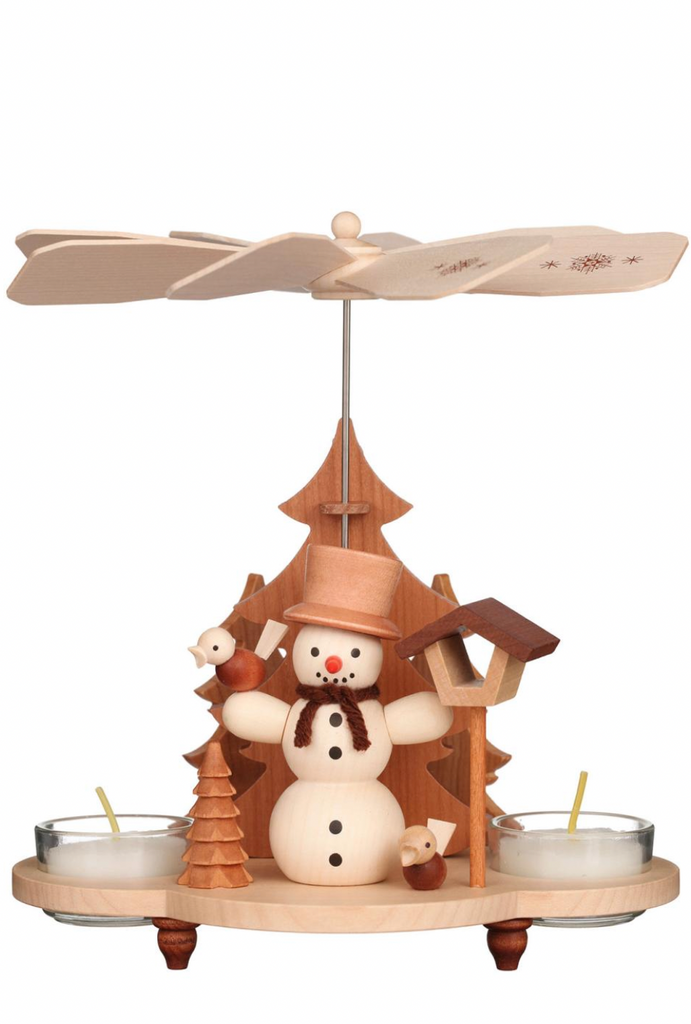 A Christian Ulbricht Snowman Pyramid handmade in Germany featuring a snowman, a Christmas tree, and a bird, with a propeller above and candle holders below.