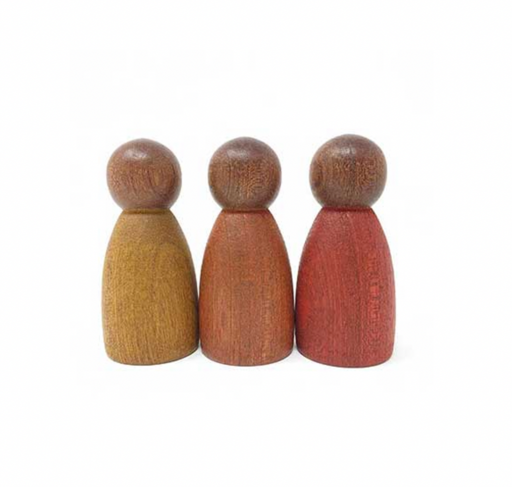 Three Grapat Dark Warm Nins dolls in varying shades of brown, crafted from sustainably forested Sapeli wood, standing in a row on a white background. Each doll has a distinct wood grain texture and color.