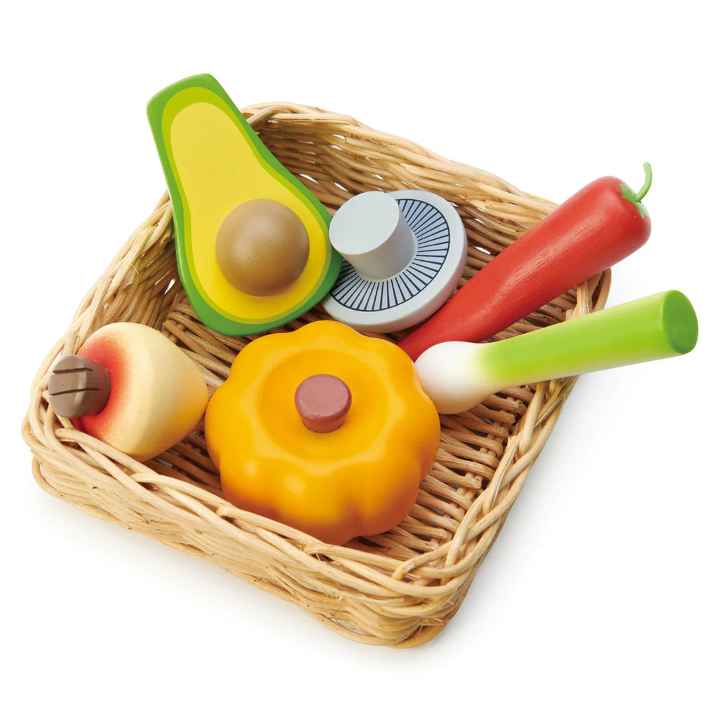 Market Basket containing colorful toy kitchen items: a red pepper, an avocado, a hot dog, an apple, and an orange, all made of plastic and designed to be cuttable.