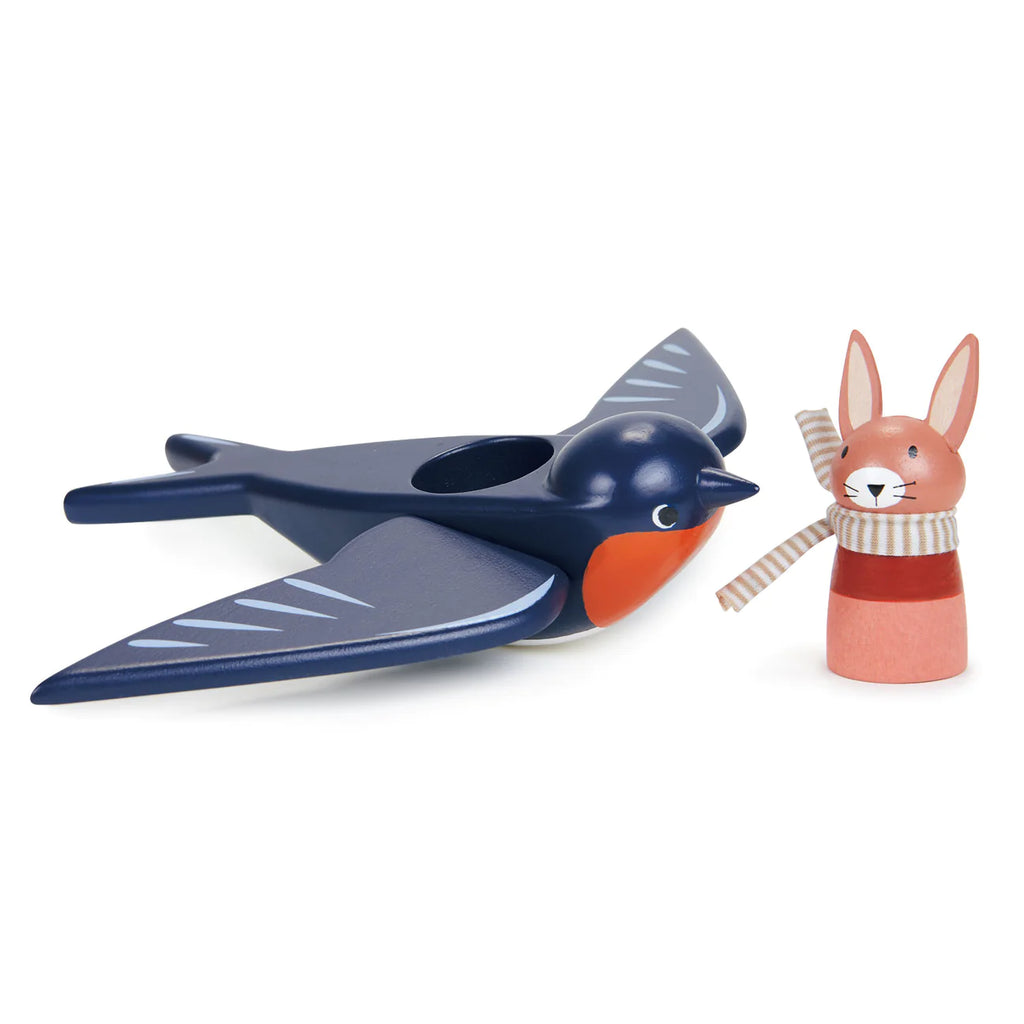 A wooden toy bird, Swifty Bird, painted in shades of blue and gray with an orange beak, next to a small wooden rabbit known as Spud the Pilot Hare in a