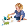 A young girl with blonde hair playing with The Friend Ship Pull Toy featuring animal figures and a boat on a white background.