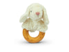 A Senger Naturwelt Sheep Teether with a soft white plush lamb head attached to a cherry wood teether. The lamb has droopy ears, a pink nose, and stitched black eyes. Handmade in Germany, the rattle is photographed against a white background.