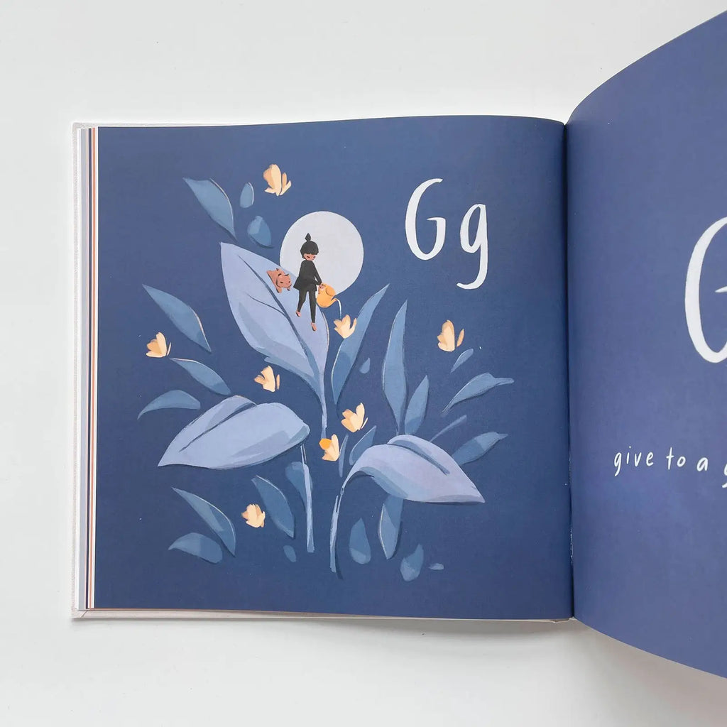 An illustrated Let's Go Explore Book opened to a blue page depicting a garden scene labeled “gg,” featuring a giant green leaf, small flowers, and a character sitting on the leaf.