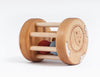 Handmade Wooden Rattle, wooden baby rattle with a cylindrical shape and a sun design, containing three colorful balls visible between horizontal bars, isolated on a white background.