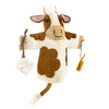 A Hand Puppet - Cow with a smiling face, brown and white patches, and a small brown tail, displayed against a white background. It holds a small yellow rope in one hand and is made from organic materials.