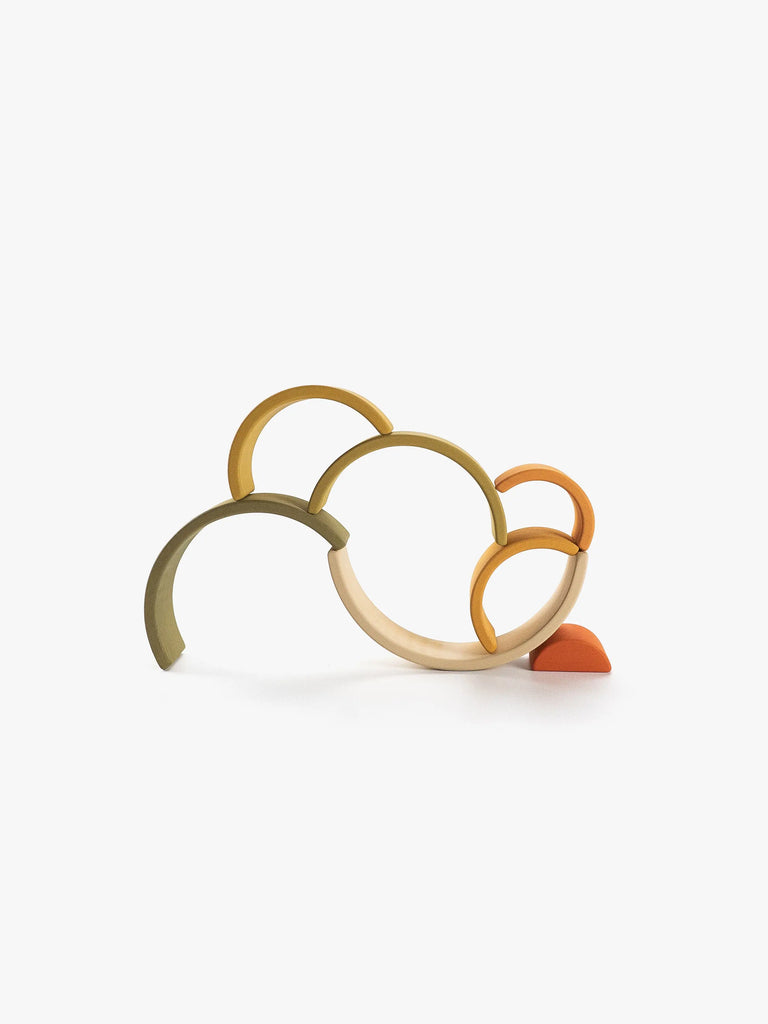 Handmade Mini Rainbow Stacker - Flower Meadow sculpture composed of interconnected metallic rings in gold, silver, and bronze colors coated in non-toxic paint, balanced on a small orange triangular base, against a white background.