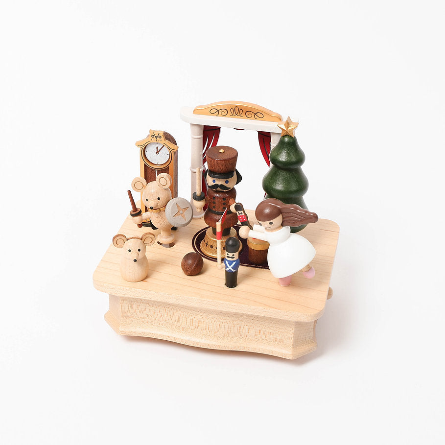 A charming Nutcracker Ballet Music Box miniature, featuring festive figurines such as a nutcracker, toys, and a christmas tree on a white background. This piece is crafted from sustainably sourced wood.