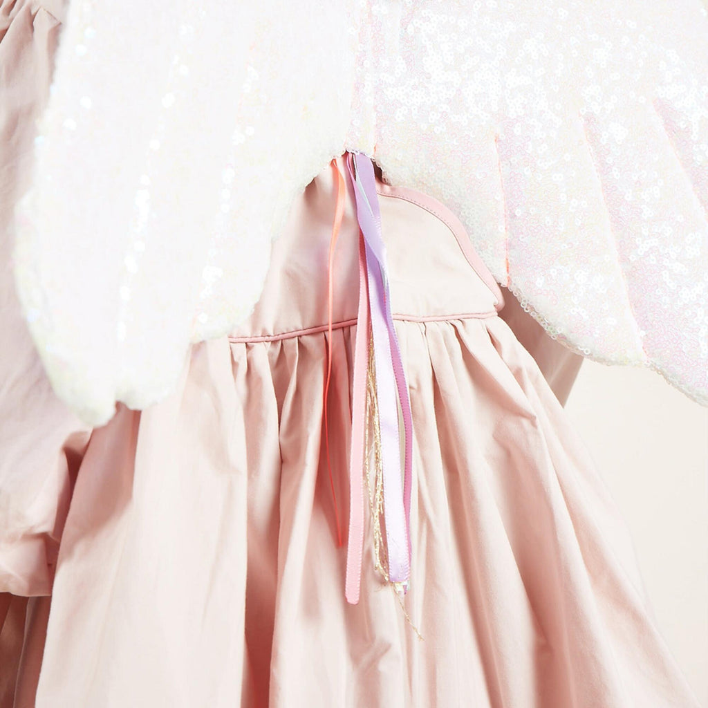 Close-up of a Meri Meri Winged Unicorn Costume with a sequined, sheer cape detail and pastel ribbons. The image focuses on the texture and sparkle of the pink iridescent sequin fabric.