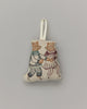 A Coral & Tusk Ice Skater Bears ornament featuring embroidered figures of a man and woman in figure skating outfits, set against a plain gray background with a fabric loop at the top for hanging.