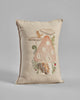 Decorative pillow featuring the Coral & Tusk Mushroom House Pocket Pillow, with large polka dots, surrounded by small plants and a foraging chipmunk, on a neutral fabric background.