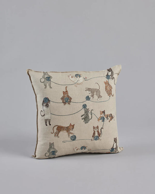 Coral & Tusk Playful Cats Pillow on a gray background featuring an embroidered print of various cats, including Siamese cats, in different poses connected by lines, suggesting play or interaction.