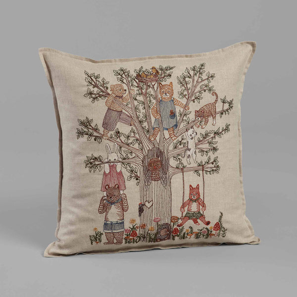 Decorative Coral & Tusk Tree of Fun Pillow featuring a detailed embroidered design of whimsical animals standing upright and behaving like humans, interacting around a central "Tree of Fun" on a neutral background.