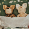 Two stuffed dolls in deer costumes photographed inside a blanket. 