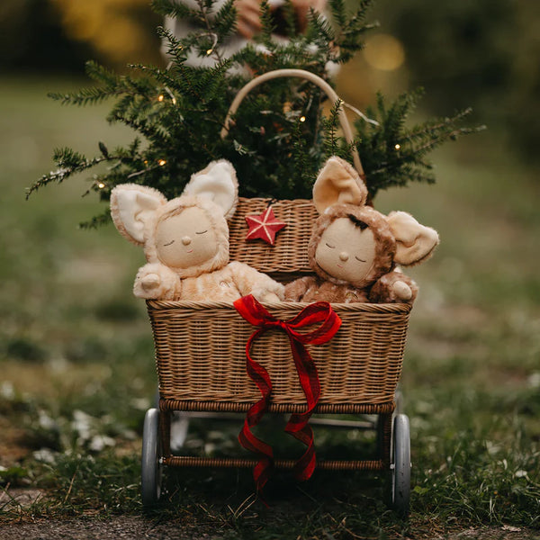 Two stuffed dolls in deer costumes photographed in a rattan wagon. 