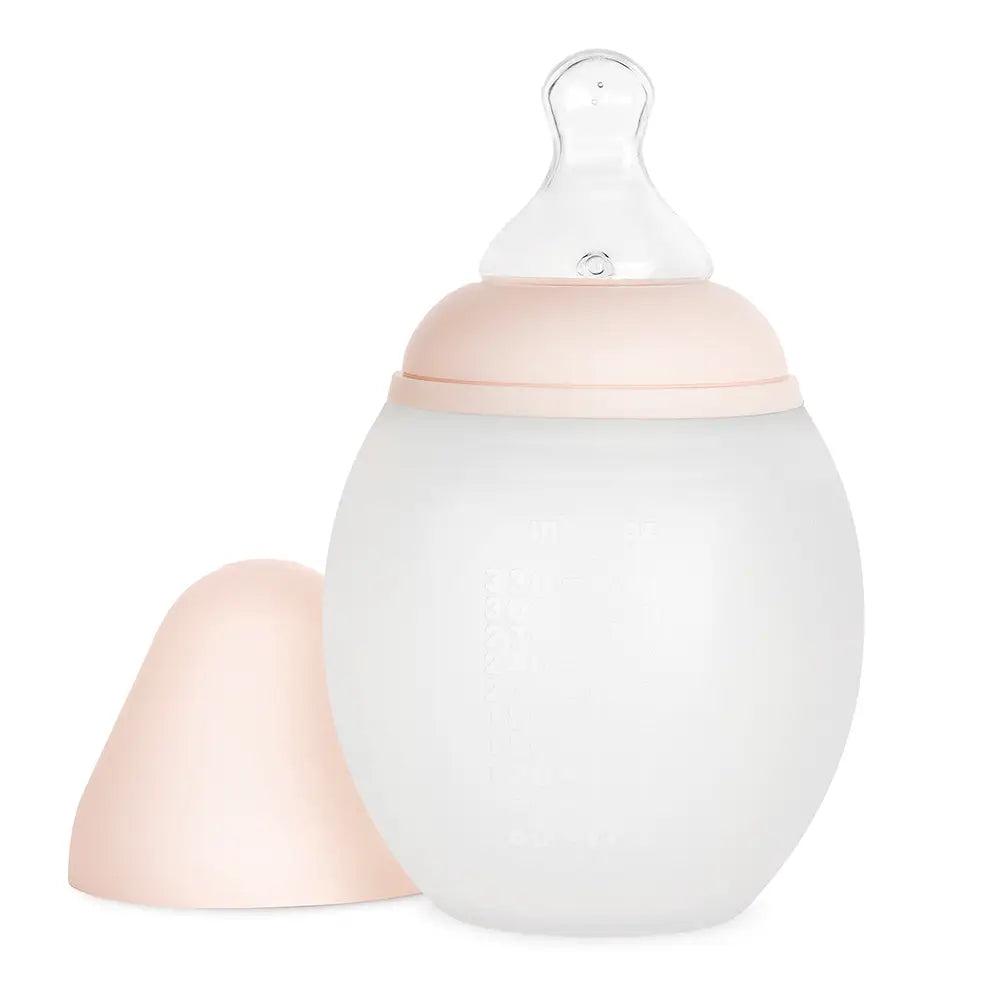 A Medical Grade Silicone Baby Bottle with measurement marks and a removable peach-colored cap, designed to mimic breastfeeding.