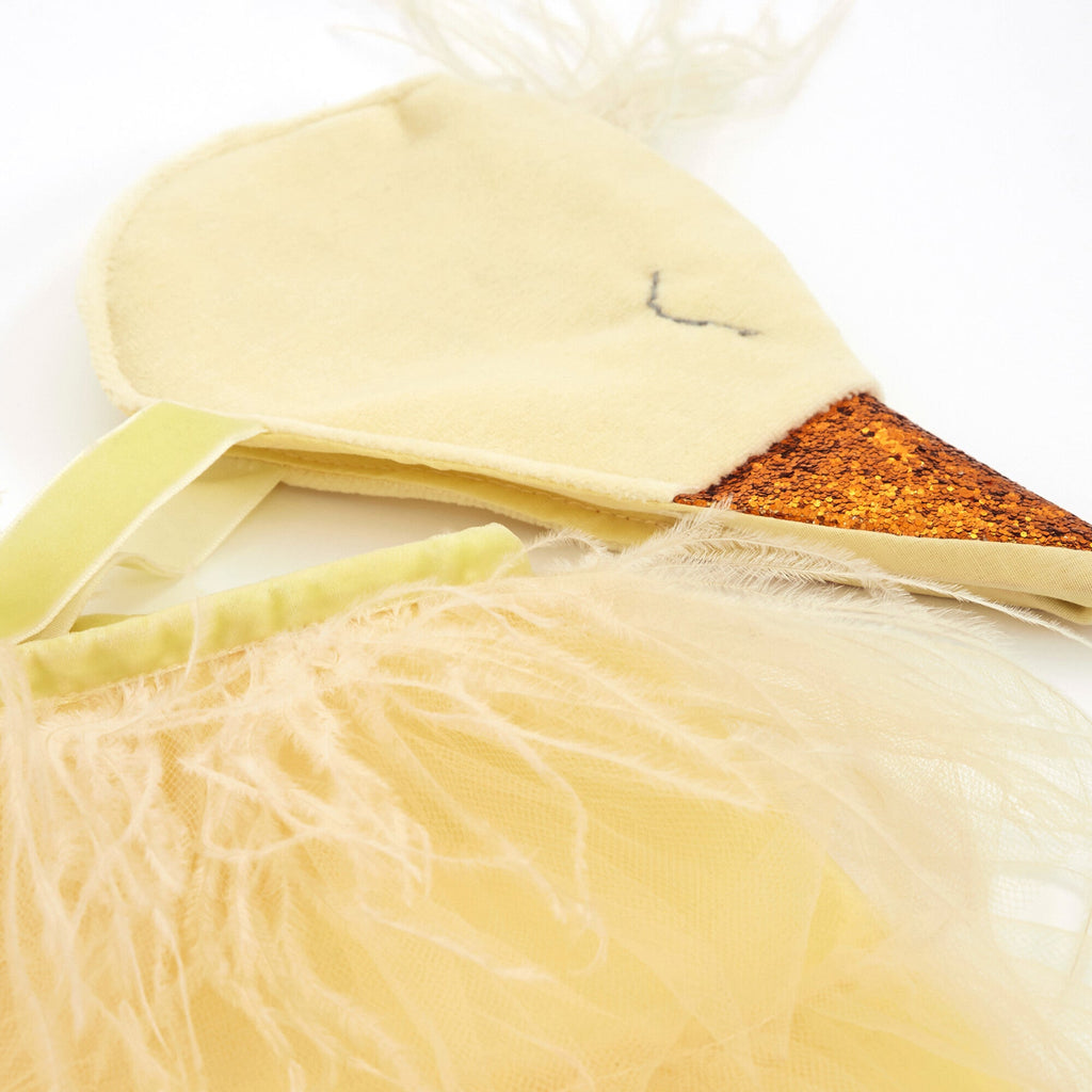 A close-up of a Meri Meri Chick Costume with a soft beige body, embroidered eye, shimmery orange textile beak, and light yellow feather details, perfect for a child's chick costume