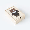 A Mix & Match Animal Tiles puzzle in the shape of a bear inside a small square wooden box, set against a plain white background. The bear has a dark brown head and a patterned body. This set is part