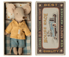 A Maileg Mouse in a box - Big Brother dressed in a yellow checkered polyester shirt and denim shorts, lying in a matchbox with vintage race car graphics, labeled "best mouse race new safety matches".