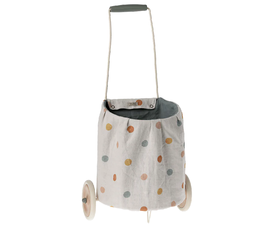 The Maileg Trolley, Multi dots - Blue is a small pushcart with a washable linen basket in colorful polka dots, two wooden wheels, and a gray handle.
