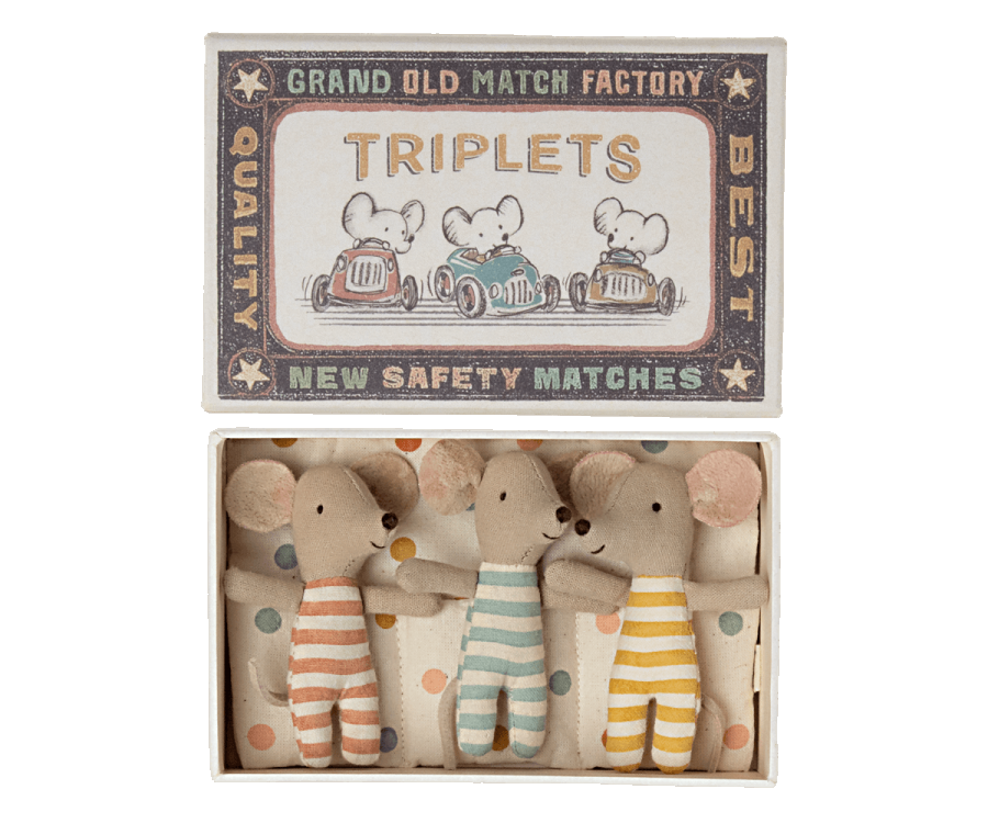A decorative Maileg | Triplets Baby Mice In Matchbox labeled "triplets" from the grand old match factory, featuring an illustration of three baby mice in a car on the cover, and holding three plush mouse toys inside with striped outfits.