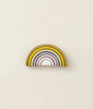A stacking toy with 7 pastel tone wooden arcs stacked into a rainbow shape. 